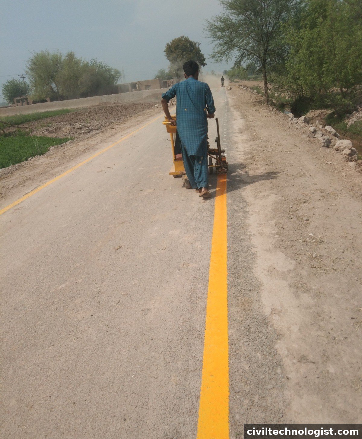 Road marking machine applying lane lines on a finished pavement